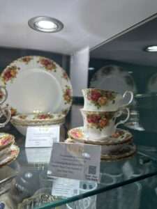 Image showing vintage teacup and saucer with a floral pattern in a glass cabinet 